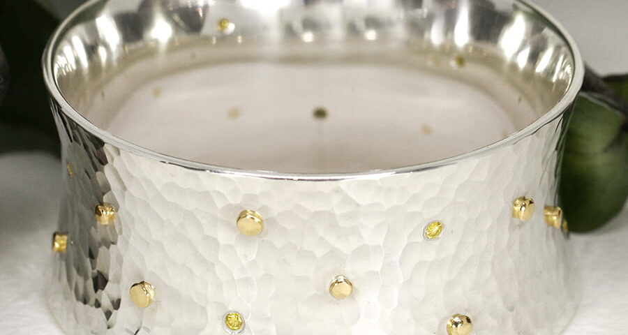 18. 'Guinivere', Sterling Silver bangle with 15 18ct Yellow gold Rivets and eight 10pt Fancy Yellow Diamonds