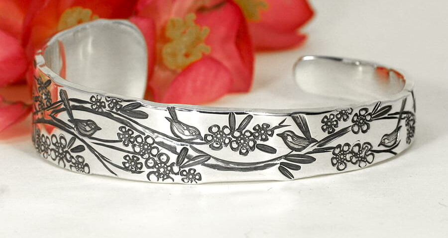 'Flowers and Wrens' sterling silver tapered cuff featuring geraldton wax flowers and australian wrens john miller design