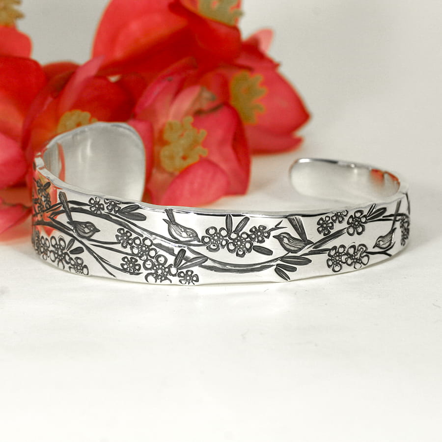 'Flowers and Wrens' sterling silver tapered cuff featuring geraldton wax flowers and australian wrens john miller design