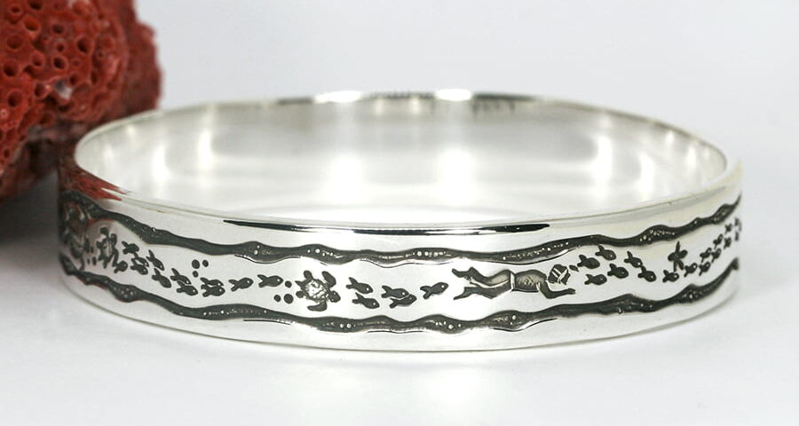 'Framed Fish' sterling silver bangle featuring diver fish turtles starfish in a wave frame