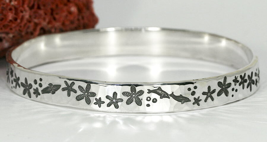 'Starfish Marine' sterling silver bangle with a hammerbeat finish featuring marine life