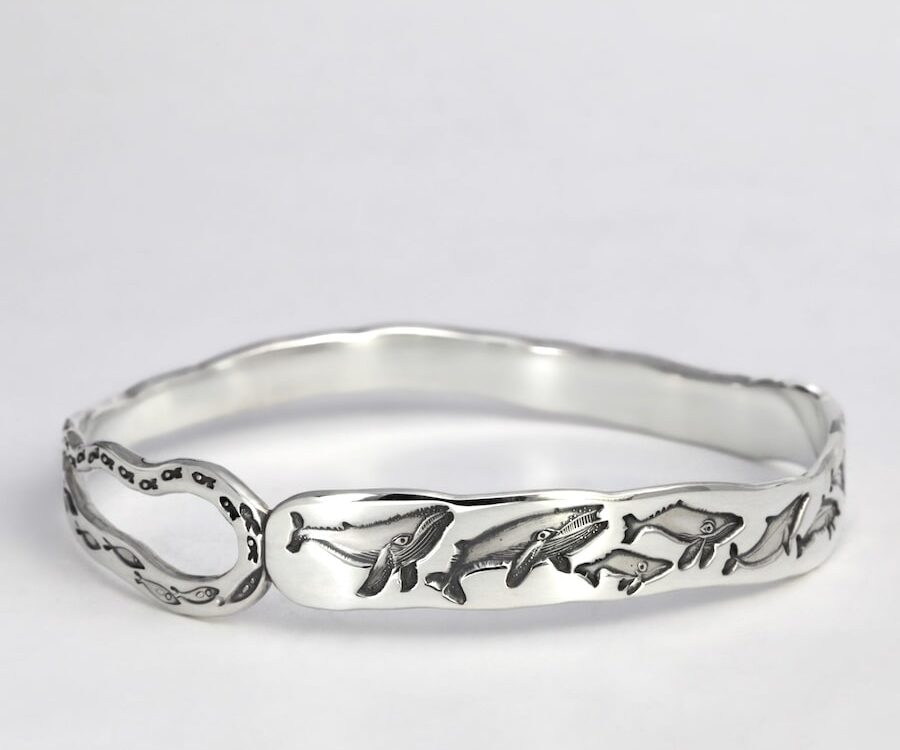 "Oceanic Wave" sterling silver cuff with design of whales dolphins and fish
